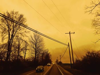 Cars on road against sky during sunset