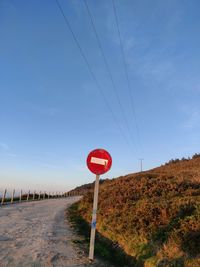 Road sign against blue sky