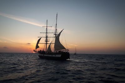 Sailboat sailing on sea against sky during sunset