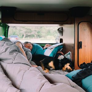 Man with dog sleeping in land vehicle