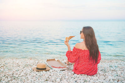 Woman on beach by sea against sky