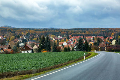 Houses by road against sky