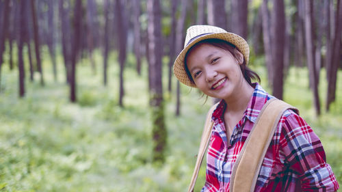 Young girl at pine forest wear hat and red shirt at phu pha man khonkaen thailand.