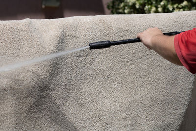 Cropped hand of man holding umbrella