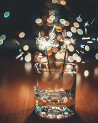 Close-up of illuminated tea light candles on table