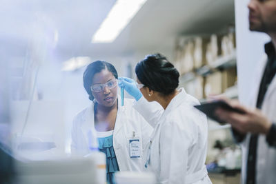 Female doctors examining test tubes in laboratory