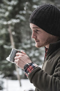 Side view of young man drinking glass