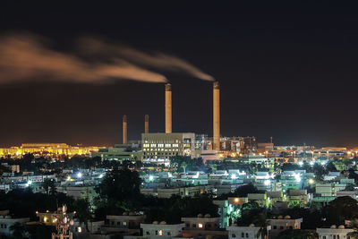 Smoke emitting from factory against sky at night