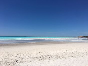 Scenic view of beach against clear blue sky