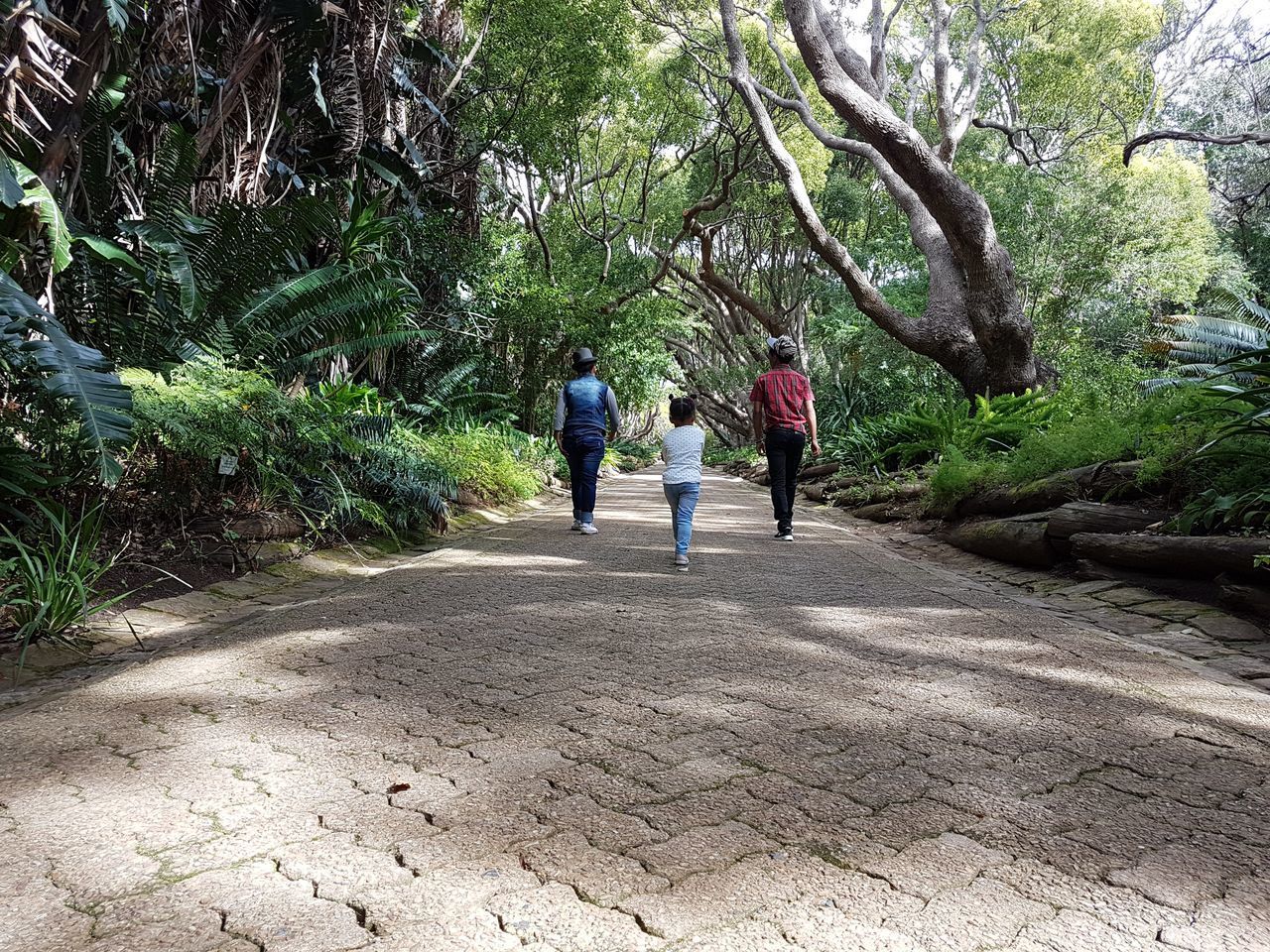 REAR VIEW OF PEOPLE WALKING ON ROAD