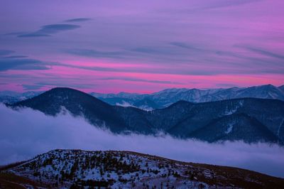 Scenic view of snow covered mountains against sky during sunset