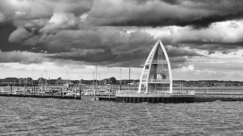 Scenic view of sea by buildings against sky