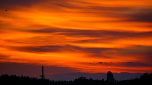 Silhouette landscape against scenic sky