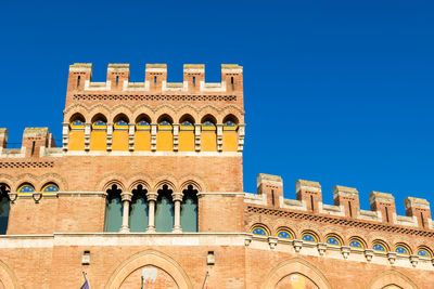 Low angle view of historic building against clear blue sky during sunny day