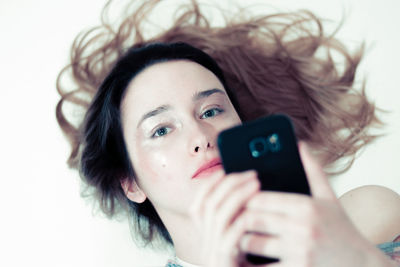 Close-up portrait of young woman using mobile phone