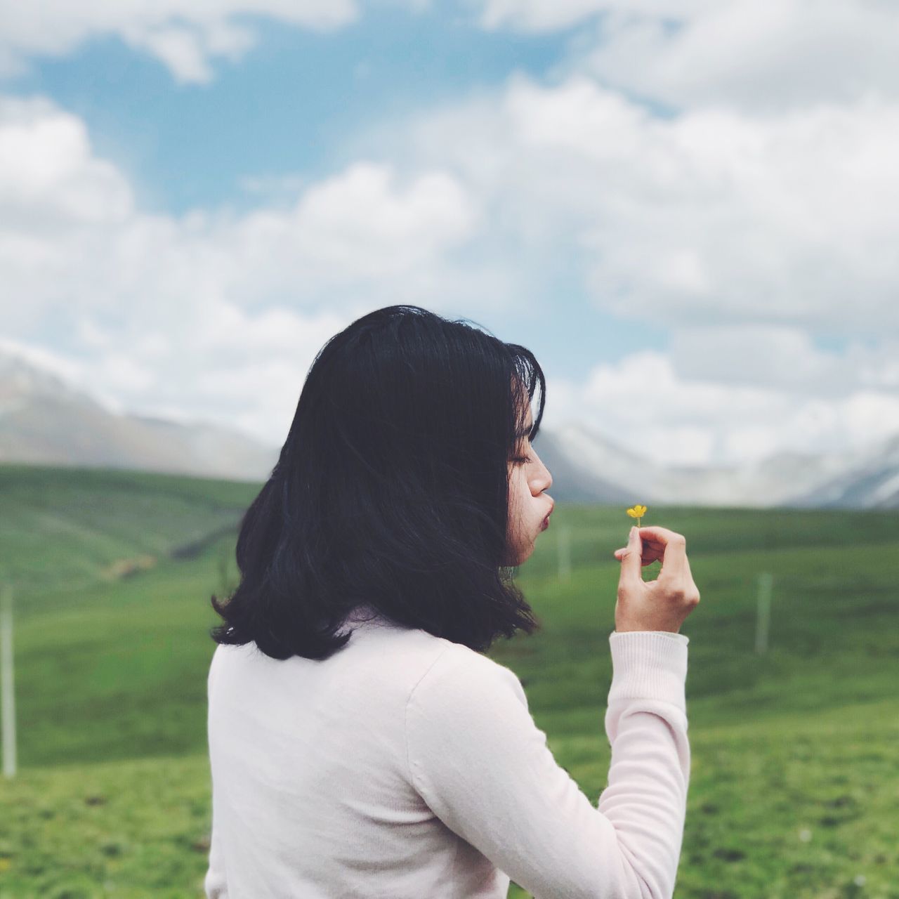 real people, one person, sky, field, holding, outdoors, focus on foreground, cloud - sky, casual clothing, day, leisure activity, lifestyles, women, headshot, green color, nature, photographing, beauty in nature, young women, technology, young adult, adult, people