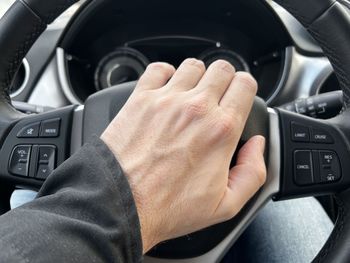 Cropped hand of man driving car