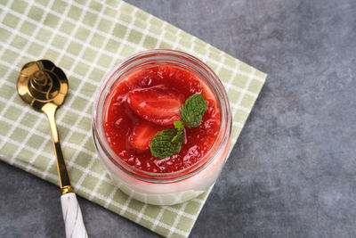 Sweet vanilla silky pudding dessert with strawberry sauce, sliced fresh strawberries and mint 