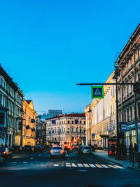 City street and buildings against clear blue sky