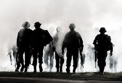 Army soldiers walking against smoke