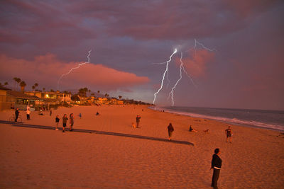 Group of people on beach against sky