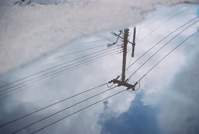 High angle view of electricity pylon reflection on puddle