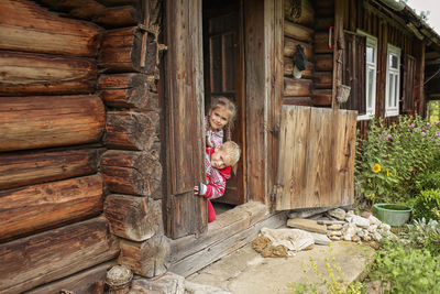 High angle view of girl standing by wooden hut