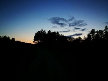 Silhouette trees on landscape against clear sky