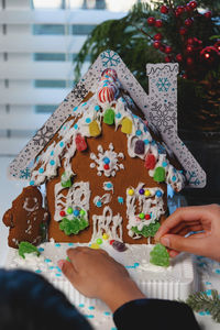 Cropped hands of woman holding model house