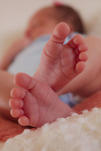 Close-up of newborn baby feet on bed at home