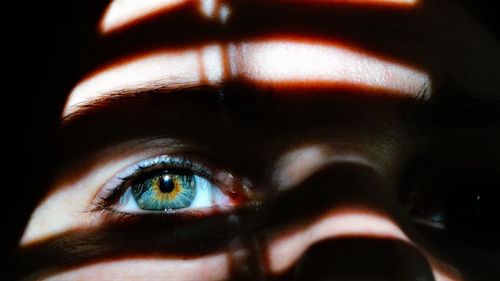 Sunlight falling on woman eye in darkroom