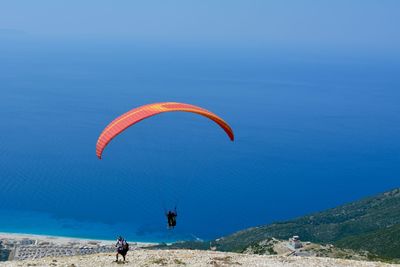 Person paragliding against blue sky