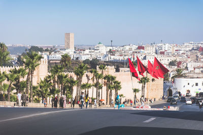 Panoramic view of people in city against clear sky