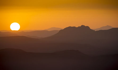 Scenic view of silhouette mountains against sky during sunset