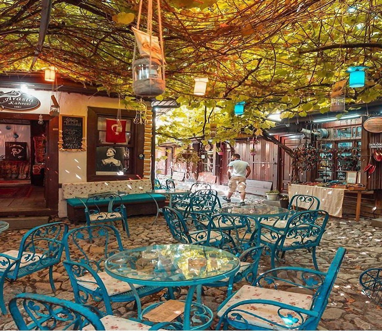 CHAIRS AND TABLES AT SIDEWALK CAFE BY BUILDING