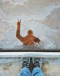 Low section of man reflection in puddle