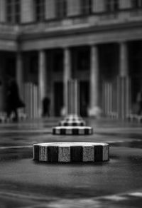 Close-up of metallic structure against buildings in city