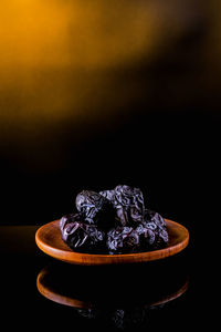 Close-up of cake on table against black background