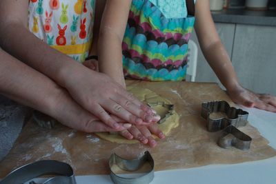 Mother and daughter hands making cookies together