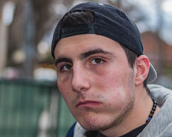 Close-up portrait of young man wearing hat