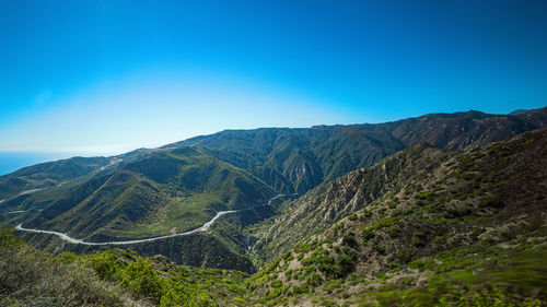 Scenic view of mountains against clear blue sky