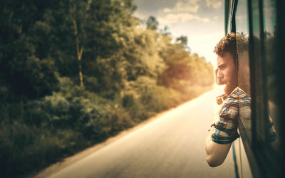 Young man looking through bus window