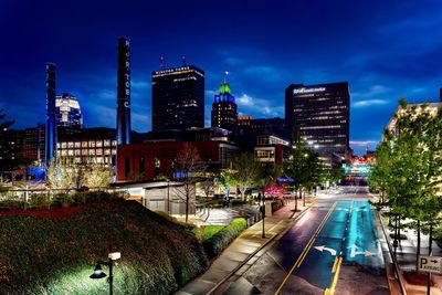 Illuminated buildings in city against sky at night