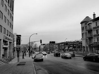 Cars on street against buildings in city