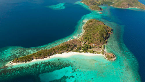 Aerial view tropical island with sand white beach, palm trees. malcapuya, philippines, palawan. 