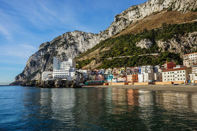 Scenic view of sea by buildings against sky