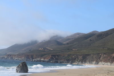 Scenic view of sea and mountains against sky