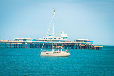 Sailboat in sea against clear sky
