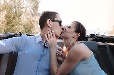 Couple kissing against car