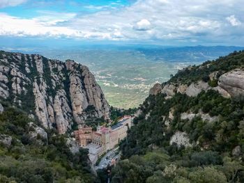 High angle view of buildings and mountain against cloudy sky